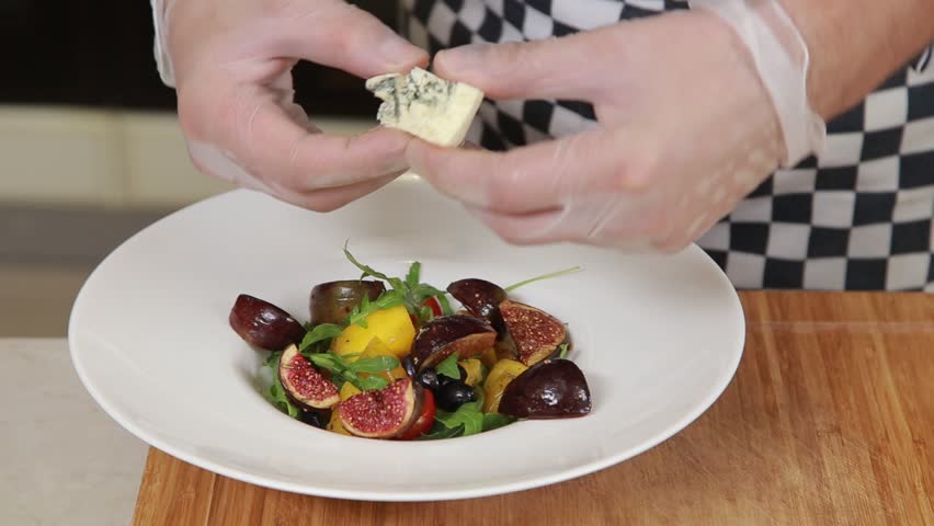 Chef is serving warm salad with figs and blue cheese