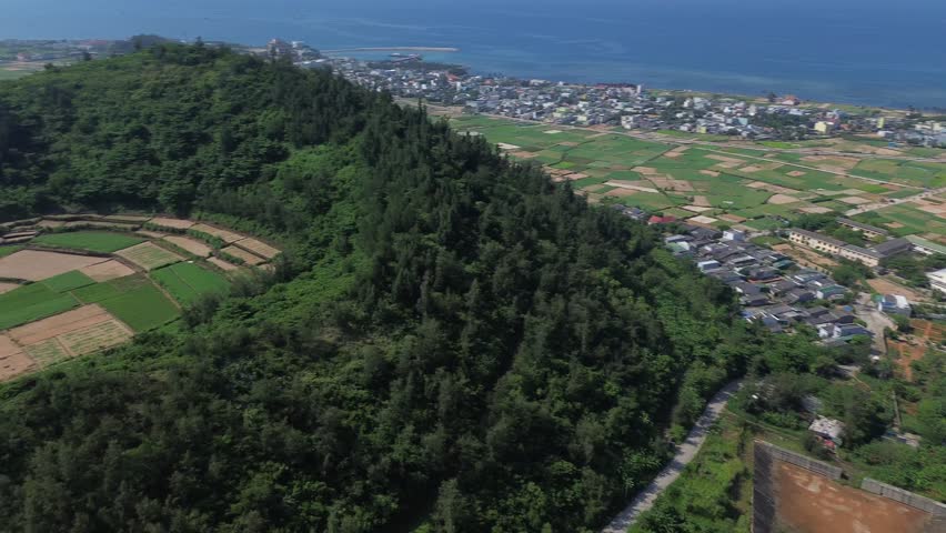 Pan left showing cultivated fields inside an extinct volcanic crater, captured on a sunny day in Ly Son Island, Vietnam.