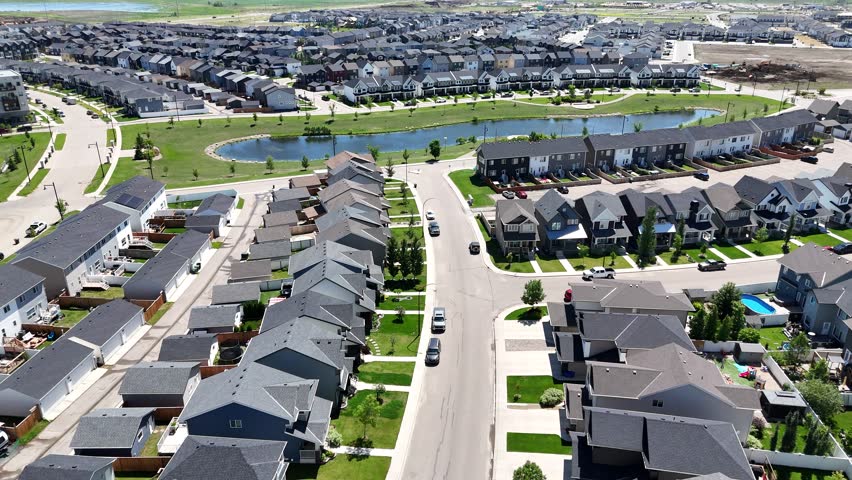 Residential neighborhood with houses and a street. The houses are mostly white and the street is lined with trees