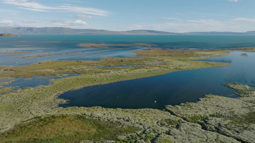 Calafate, Argentina: side drone motion reveals pristine Patagonian lagoon system with turquoise waters meandering through golden steppe landscape.