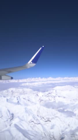 Airplane Wing Over Snowy Mountains – High Altitude Aerial View