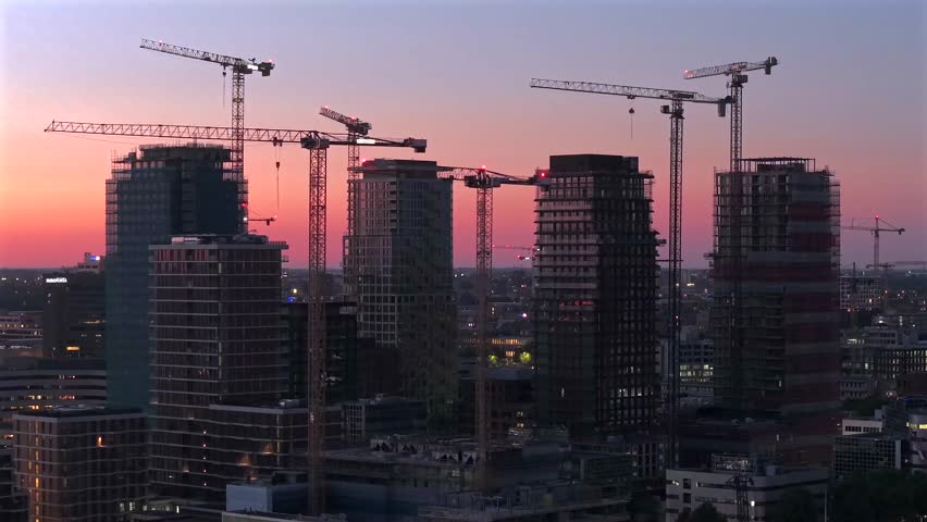 Tower Cranes over Amsterdam South Skyline at Dusk during High-Rise Construction
