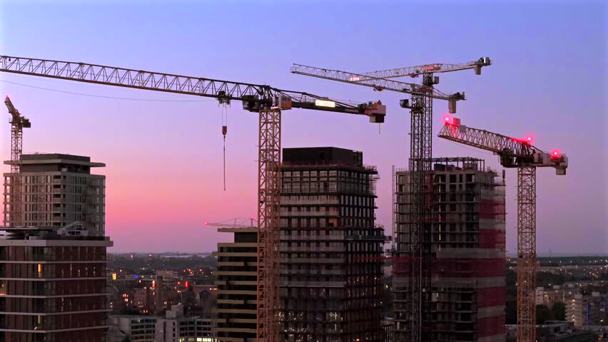 Tower Cranes over Amsterdam South Skyline at Dusk during High-Rise Construction