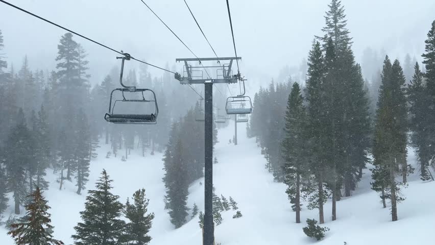 Chairlift Mammoth mountain ski resort The Hemlocks main lodge winter feet of snow dumping snowy blizzard on ski snowboard trail run California cloudy foggy backcountry forest follow motion