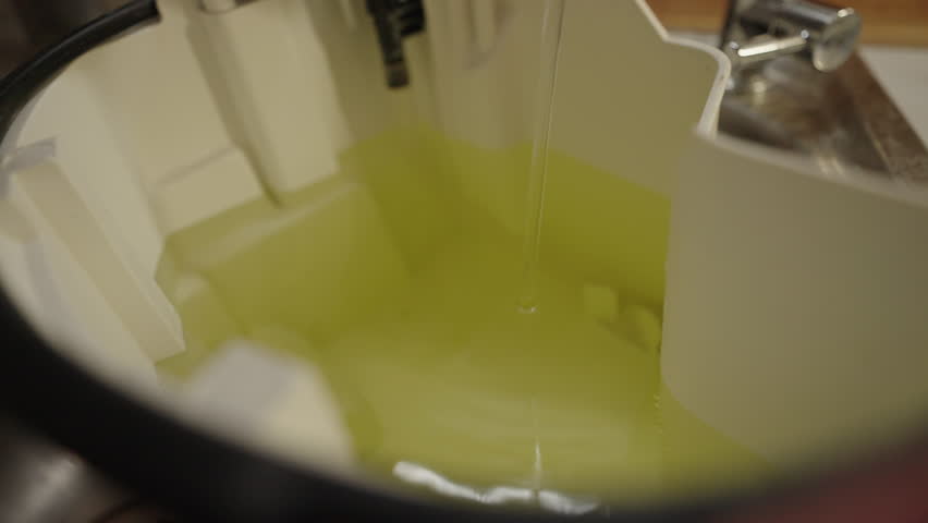 Filling clean water into vacuum cleaner container in sink, preparing for thorough house cleaning, close-up, nobody, no people, slow motion. Concept of hygiene and cleanliness in domestic environment.