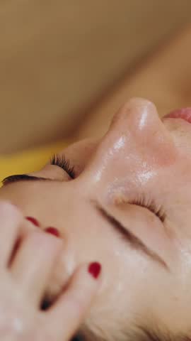 Cosmetology, facial massage. close-up. woman is lying on couch and getting facial massage, tonied muscles and facial skin lymphatic drainage, at beauty clinic. Skin care, anti-aging procedure. cosmeti