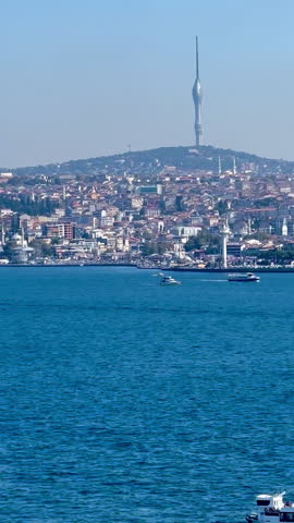A view of Istanbul with the cityscape, a tower in the background, and boats on the water, showcasing a bright day, tc01
