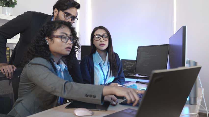 Expert IT team executing complex algorithm design and blockchain integration on multiple digital interfaces. Focused on decentralized solutions and neural network architecture in a cutting-edge develo