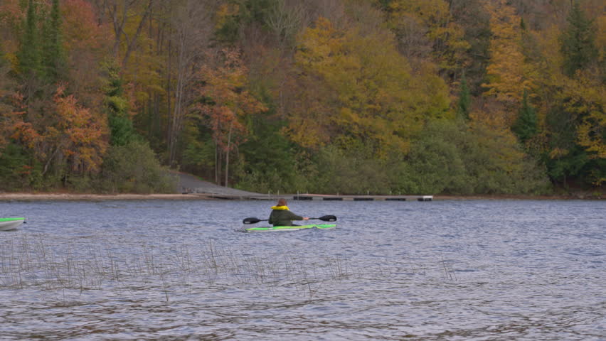 Kayaking in a serene lake surrounded by colorful autumn trees
