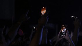 Hands holding smartphones capture the excitement of a live music concert in a dark setting, with bright screens illuminating the atmosphere and enhancing the vibrant crowd energy - Powered by Shutterstock - Get 15% off with code: PIKWIZARD15