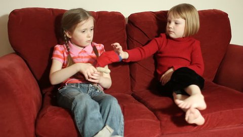 Sisters fighting - two young girls fighting over a toy doll