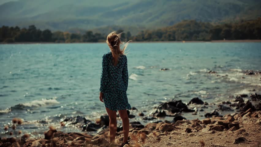 woman in a floral dress standing by a serene lake, with mountains and trees . Nature, tranquility, travel, and relaxation. Outdoor solitude scenic view tranquil scene. mountain view nature harmony 