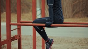person in dark athletic wear performs dips on parallel bars at an outdoor workout station, focusing on fitness and strength training. Outdoor activity park fitness. Exercising body street gym fitness - Powered by Shutterstock - Get 15% off with code: PIKWIZARD15
