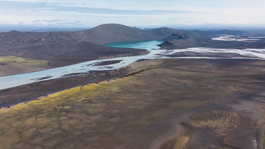 River flows into famous Skyggnisvatn lake on Iceland island. Aerial approaching wide shot. Beautiful nature of volcano island.
