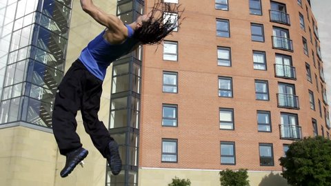 Tumble - a free runner back flips in an urban setting in super slow motion