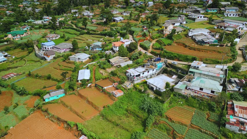 Aerial footage captures scenic Nuwara Eliya with terraced farms, village homes, and the majestic Lover's Leap Waterfall. Ideal for tourism, nature, travel or eco-promo concepts.