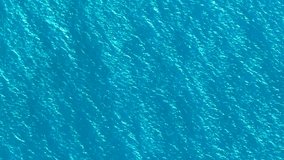 Aerial video of blue sea water background and sun reflection. Drone flight over turquoise water surface in open ocean. Flying over sea from above. Sea sunrise, ripples of ocean waves. - Powered by Shutterstock - Get 15% off with code: PIKWIZARD15