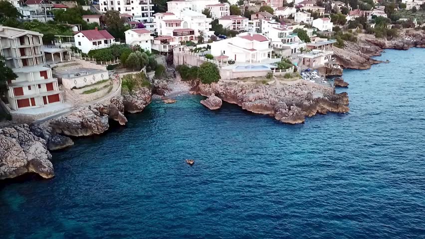 A drone video over the coastline of Dobra Voda and out to the Mediterranean Sea at sunset in Montenegro