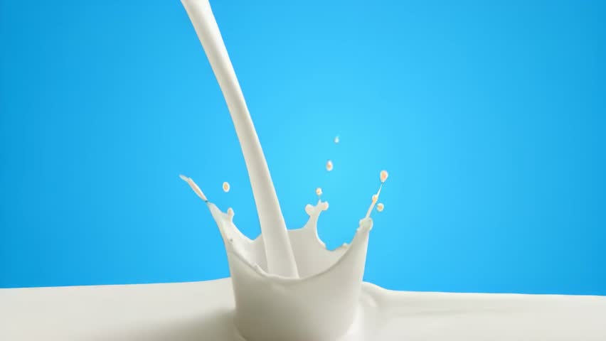 Pouring milk creates beautiful ripples and waves. Milk, Pouring, Slow Motion, Blue Background, Studio Shot, High-Speed Capture