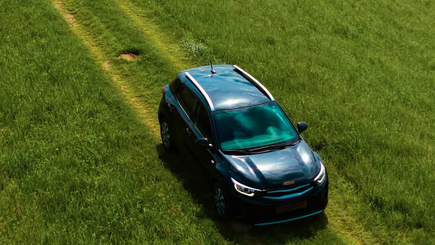 Car driving on road over hill, wheels crossing bumps. Vehicle moving along hillside path, tires passing uneven spots. Automobile riding on sloped track, wheels rolling over rough patches