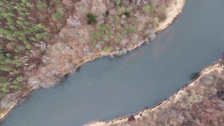 Aerial view of a winding river with a small island and surrounding forest.