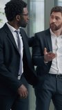 Vertical view two multiracial business men in office Caucasian sad frustrate businessman male near window African American guy partner supporting calming friendship businessmen discussing work problem - Powered by Shutterstock - Get 15% off with code: PIKWIZARD15