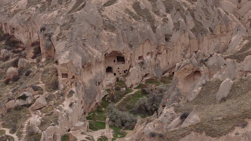 Aerial perspective of Cappadocia's rugged terrain, where nature and history merge. The region's carved dwellings and unique geological formations create a mesmerizing sight
