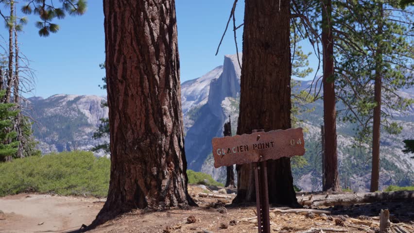 Footage featuring the Glacier Point sign in Yosemite National Park, California, with a scenic view of Half Dome in the background.