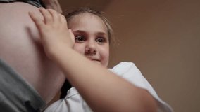 pregnant woman close-up belly. little girl hugs her mother belly. happy family daughter baby pregnancy newborn concept. baby listening to pregnant mother belly. happy family expecting newborn - Powered by Shutterstock - Get 15% off with code: PIKWIZARD15