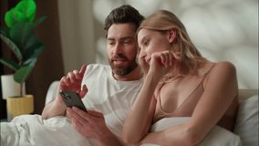 Family happy Caucasian couple discussing application in bedroom boyfriend play digital game mobile phone woman buying delivery online morning bed girlfriend man shopping Internet partners type screen - Powered by Shutterstock - Get 15% off with code: PIKWIZARD15