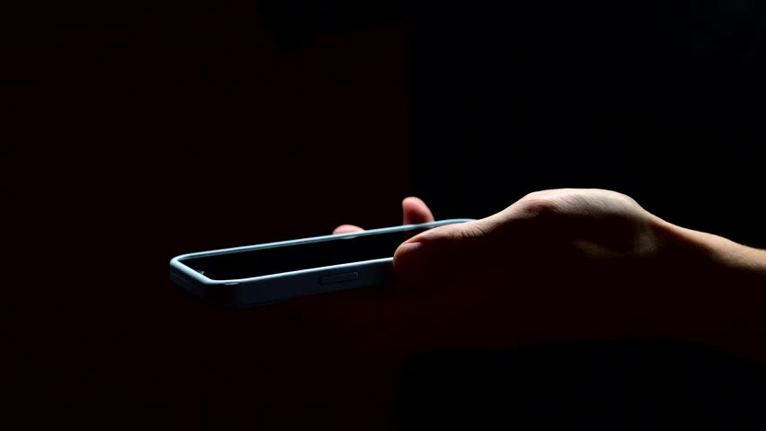 A man gives someone his phone.
A man shakes his phone in front of the camera.
Mobile phone in a trembling hand close-up on a black phone.
Modern smartphone in hand