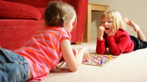 Two little girls playing a board game - the younger one wins!