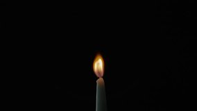 Tiny candle staying on black background in total stillness. Flickers move slightly across quiet walls of night. One steady flame giving feeling of warmth or devotion. Wax taper burning on dark surface - Powered by Shutterstock - Get 15% off with code: PIKWIZARD15