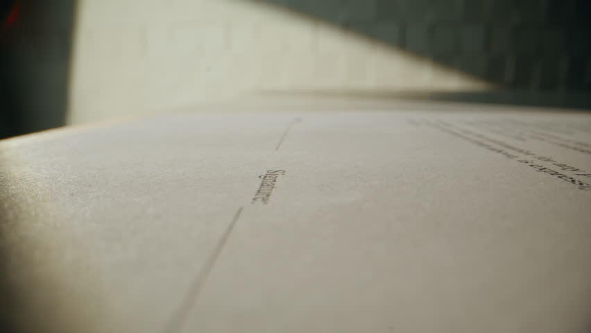 Businessman hand signing contract holding pen at office desk closeup. Unrecognizable person manager putting signature on legal paper at workplace. Man executive legalize financial agreement indoors