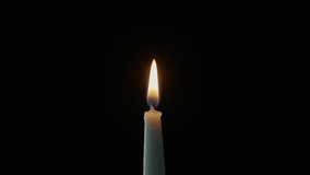 Lit wax taper standing alone against dark backdrop. Gentle flame moving on wind in quiet space. Single candle glowing steadily creating romantic setting on black. Thoughtful reflective mood concept - Powered by Shutterstock - Get 15% off with code: PIKWIZARD15