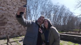 Happy couple taking selfies in rural setting near old building - Powered by Shutterstock - Get 15% off with code: PIKWIZARD15
