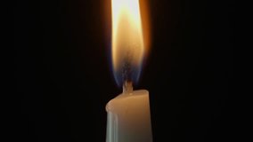 Gentle air blowing out candle flame in dark studio closeup shot. Taper wax fire finishes on black surface. Smoke drifts up from wick slowly. Peaceful theme. Symbol of memory hope spiritual energy - Powered by Shutterstock - Get 15% off with code: PIKWIZARD15
