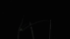 Thin wire thread heats slowly inside classic bulb against dark backdrop. Bright line glowing with pulsing energy in silent space. Vintage lamp core shining soft yellow light through clear glass indoor - Powered by Shutterstock - Get 15% off with code: PIKWIZARD15