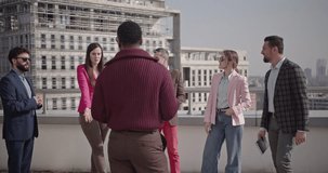 A diverse team of business professionals collaborates during a morning meeting on a rooftop terrace, overlooking the cityscape. - Powered by Shutterstock - Get 15% off with code: PIKWIZARD15