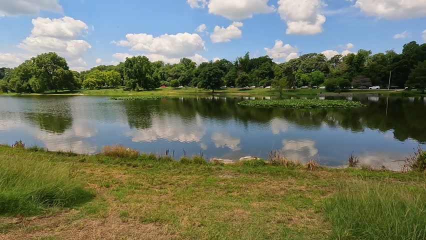 Beautiful Summer lake scene at Forest Park in St. Louis, Missouri, USA. Clouds and trees reflect upon the water. City park located in the heart of the city.