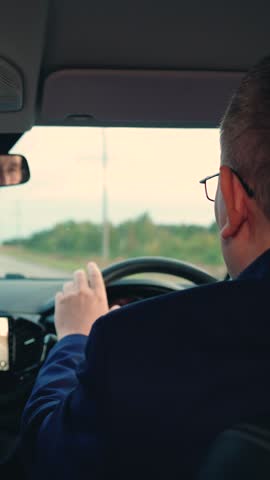 Businessman in formal suit drives car to work. Successful people driving their car. Business man drives car. Man travels by car outside city. Luxurious Purchase rental insurance of transport vehicles