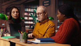 Mature diverse colleagues writing notes and ideas in campus study room, focusing on academic graduation preparation at the college library. Learning for personal development. Camera B. - Powered by Shutterstock - Get 15% off with code: PIKWIZARD15