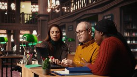 Mature diverse colleagues writing notes and ideas in campus study room, focusing on academic graduation preparation at the college library. Learning for personal development. Camera A. - Powered by Shutterstock - Get 15% off with code: PIKWIZARD15