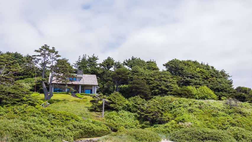 4K footage of a stunning house on Cannon Beach, Oregon, overlooking the Pacific Ocean with a scenic forested backdrop and coastal vibes.