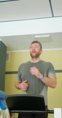 A middle-aged man runs on a treadmill. Keeping fit in your 40s. Realtime 30 fps 4k footage.