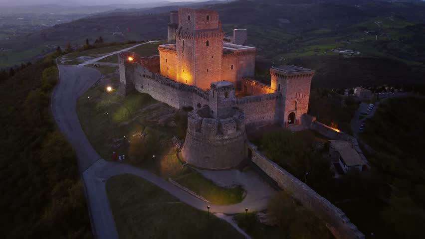 Establisher aerial view of Rocca Maggiore in Assisi's city, Umbria, Italy, dusk, 4k