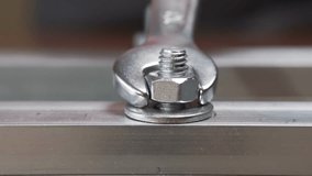 Close-up of a threaded nut and bolt. A hand using a wrench tightens a nut on a bolt - Powered by Shutterstock - Get 15% off with code: PIKWIZARD15