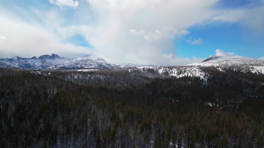 Winter Spring Mammoth Mountain ski resort California Hemlocks Ritter Range Sierra Nevadas Minarets Summit vista sunny blue sky snowy gray clouds over jagged peaks Inyo Sierras National Forest forward