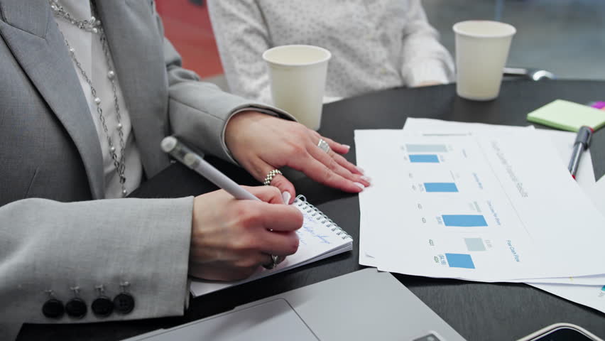 Strategic business meeting with documents on revenue trends and company performance, close-up on team collaboration. - Powered by Shutterstock - Get 15% off with code: PIKWIZARD15