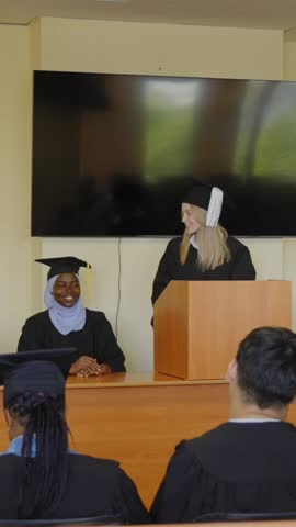 A young woman stands at the lectern and delivers a graduation speech to her classmates. 